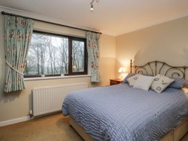 A bedroom with a bed and curtains at Beech Brae Kendal