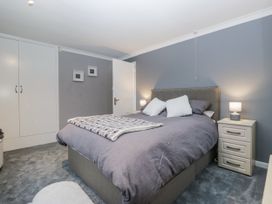 A bedroom with a bed and nightstands at Beech Brae in Kendal