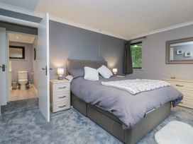 A bedroom featuring a bed and a doorway leading to a bathroom at Beech Brae in Kendal