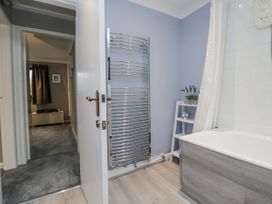 A bathroom with a bath tub and towel rack at Beech Brae in Kendal