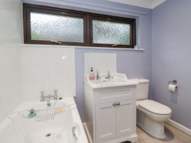 A bathroom with a bath tub, sink, and toilet at Beech Brae Kendal