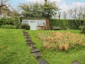 A garden with a shed and bench at Beech Brae in Kendal