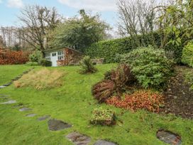 A garden with a shed and pathway at Beech Brae in Kendal