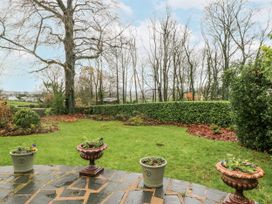 A garden with flower pots and trees at Beech Brae Kendal