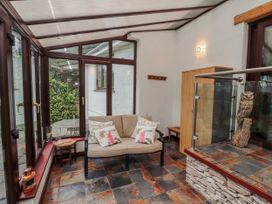A conservatory with a sofa and coffee table at Beech Brae in Levens