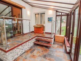 A conservatory with glass railing and wooden chest at Beech Brae in Levens