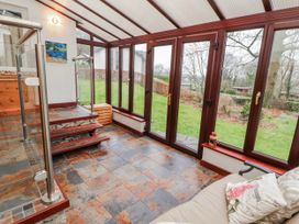 A conservatory with a staircase and glass doors at Beech Brae in Levens