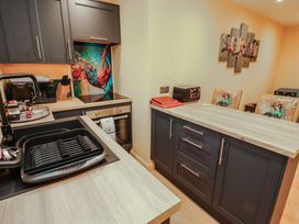 A kitchen with cabinets oven sink and dining chairs at The Nook 