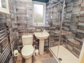 A bathroom with a toilet, sink, and shower at The Nook in 