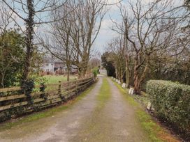 A driveway lined with trees and fences at The Nook in 