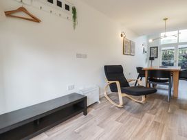 A dining area with a wooden table black chairs and a black armchair with wooden arms at Treveglos in Porthtowan