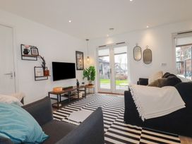 A living room with black and white striped rug sofas and a television at Treveglos in Porthtowan