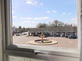 A view of a roundabout with a water fountain and buildings seen through a window at No 108 Waterside in Corton