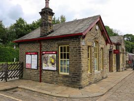 A stone building with windows and posters at Oxenhope train station
