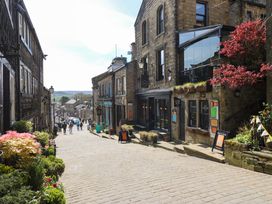 A cobblestone street with stone buildings and pedestrians in a town