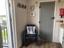 An entryway with a chair and hooks at Little Acre in Oxenhope
