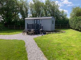 A shed with a deck and grill in a green area at Little Acre in Oxenhope