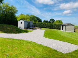An outdoor area with a shepherd's hut and garden shed at Little Acre in Oxenhope