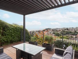An outdoor patio with a table and chairs overlooking the sea at 15 Summerland Avenue Dawlish