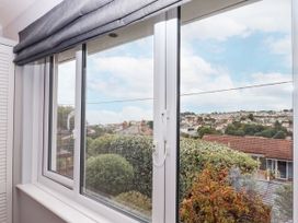 A window with a view of houses and bushes at 15 Summerland Avenue Dawlish