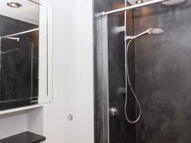 A shower with a mirror and sink in a bathroom at 15 Summerland Avenue Dawlish