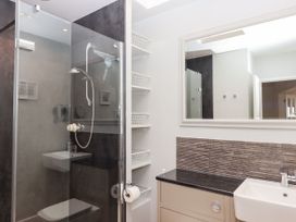A bathroom with shower, sink, and shelves at 15 Summerland Avenue, Dawlish