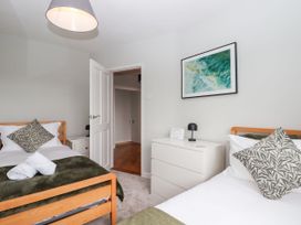 A bedroom with two beds and a bedside table at 15 Summerland Avenue in Dawlish