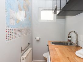 A bathroom with a sink, toilet and a world map at 15 Summerland Avenue, Dawlish
