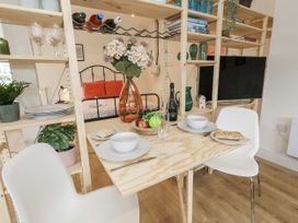 A dining area with a table set for two at Sea Pink Studio in Swanage