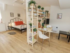 A studio with a bed and dining area at Sea Pink Studio in Swanage