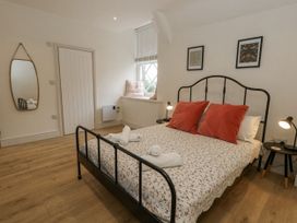 A bedroom with a bed and mirror at Sea Pink Studio in Swanage