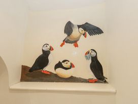 A wall painting of puffins at Sea Pink Studio in Swanage