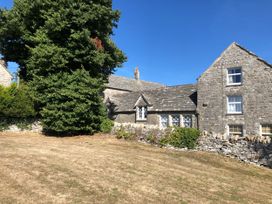 A house with trees and grass at Sea Pink Studio in Swanage