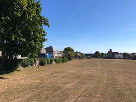 An outdoor area with trees and houses near a playground at Sea Pink Studio in Swanage