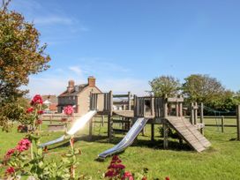 A playground with slides and flowers at Sea Pink Studio in Swanage