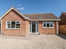 Exterior view of a single-story brick house with a black front door and two windows at The Hideaway in Bempton near Flamborough