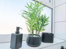 A window ledge with a potted plant a soap dispenser and a container at The Hideaway in Bempton near Flamborough