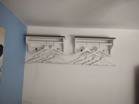 A bedroom with wall-mounted shelves and coat hangers at Llety Beddgelert