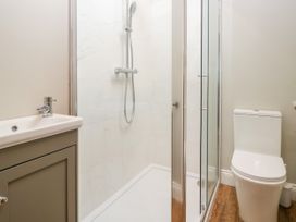 A bathroom with a shower, sink, and toilet at Swirral Edge Cottage in Glenridding