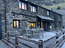 A house exterior with a table and chairs at Swirral Edge Cottage in Glenridding