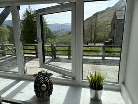 A window with a plant and a sculpture at Swirral Edge Cottage in Glenridding