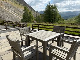 An outdoor seating area with a table and chairs at Swirral Edge Cottage in Glenridding