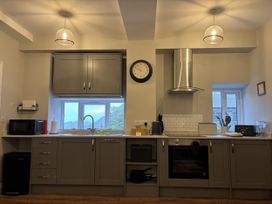 A kitchen with cabinets, oven, and window at Swirral Edge Cottage in Glenridding