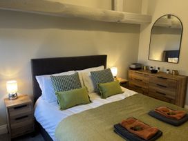 A bedroom with a bed and wooden dresser at Swirral Edge Cottage, Glenridding