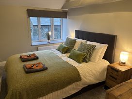 A bedroom with a bed and nightstand at Swirral Edge Cottage in Glenridding