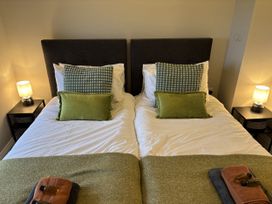 A bedroom with twin beds and nightstands at Swirral Edge Cottage in Glenridding
