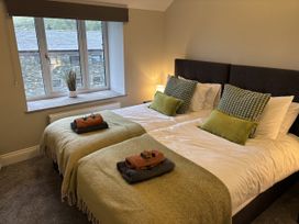 A bedroom with two beds and a window at Swirral Edge Cottage in Glenridding