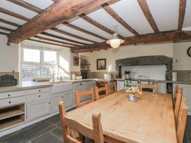 A kitchen with a wooden table and chairs at High Ickenthwaite Farmhouse in Ulverston
