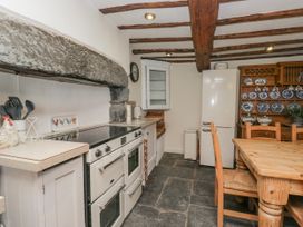 A kitchen with an oven and a table at High Ickenthwaite Farmhouse in Ulverston