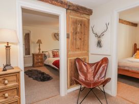 A bedroom with a chair and lamp at High Ickenthwaite Farmhouse in Ulverston
